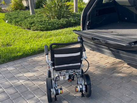 Putting the electric wheelchair in and out of a car trunk.